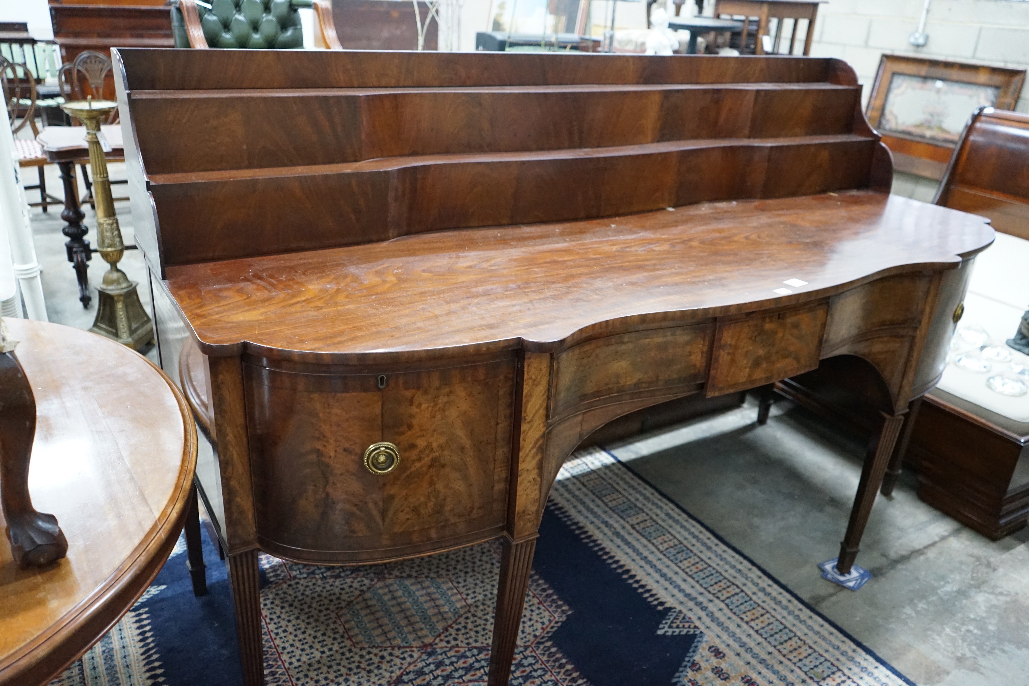 A George IV mahogany serpentine sideboard, width 214cms, depth 86cms, height 132cms.